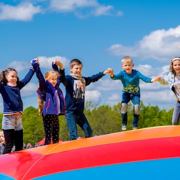 Kinder hüpfen beim WOBAU-Feriebspaß im Elbauenpark.