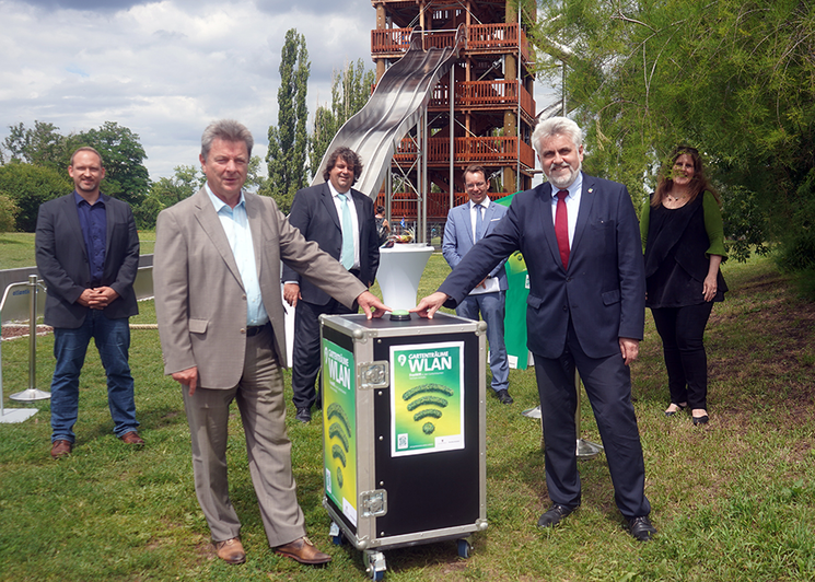 Professor Armin Willingmann, Minister für Wirtschaft in Sachsen-Anhalt und Dr. Lutz Trümper ,Oberbürgermeister Magdeburgs decken den Startknopf für das neue WLAN-Netz des Elbauenparks vor der Kulisse des neuen Rutschenturms.