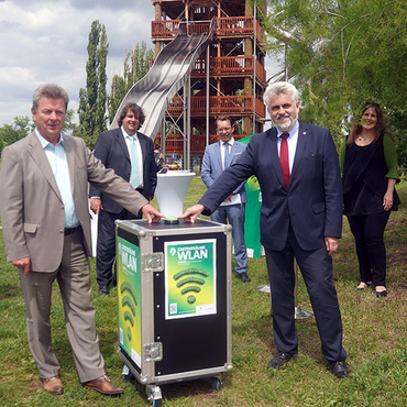 Professor Armin Willingmann, Minister für Wirtschaft in Sachsen-Anhalt und Dr. Lutz Trümper ,Oberbürgermeister Magdeburgs decken den Startknopf für das neue WLAN-Netz des Elbauenparks vor der Kulisse des neuen Rutschenturms.